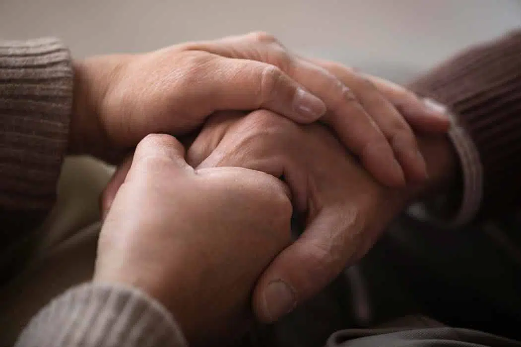 holding hands of elderly parent