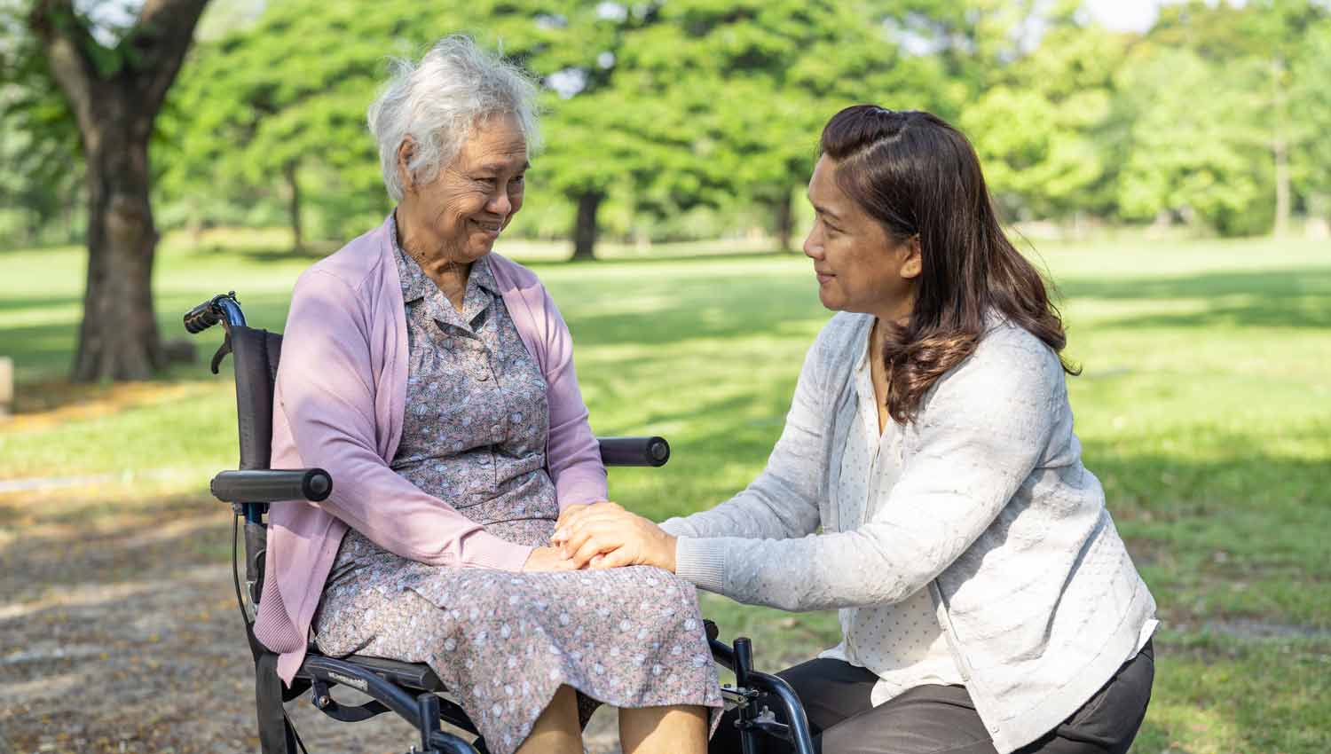 caregiver daughter in the park with a disabled mother