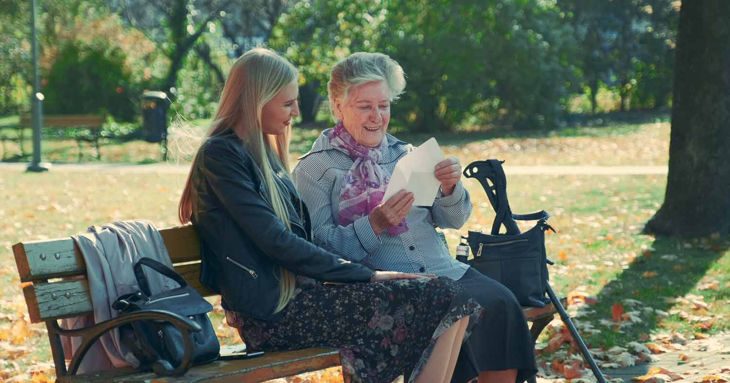 woman sitting on a bench with elderly woman