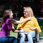 daughter outdoors with disabled mother in a wheelchair