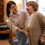 caregiver family member helping elderly woman walk