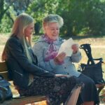 daughter caregiver with senior mother in a park sitting