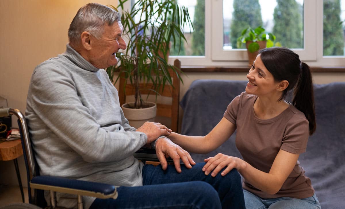 smiling daughter caregiver holding disabled father's hand