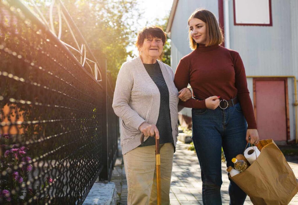 family caregiver helping elderly mother get groceries