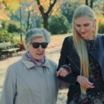 daughter helping elderly mother walking in the park