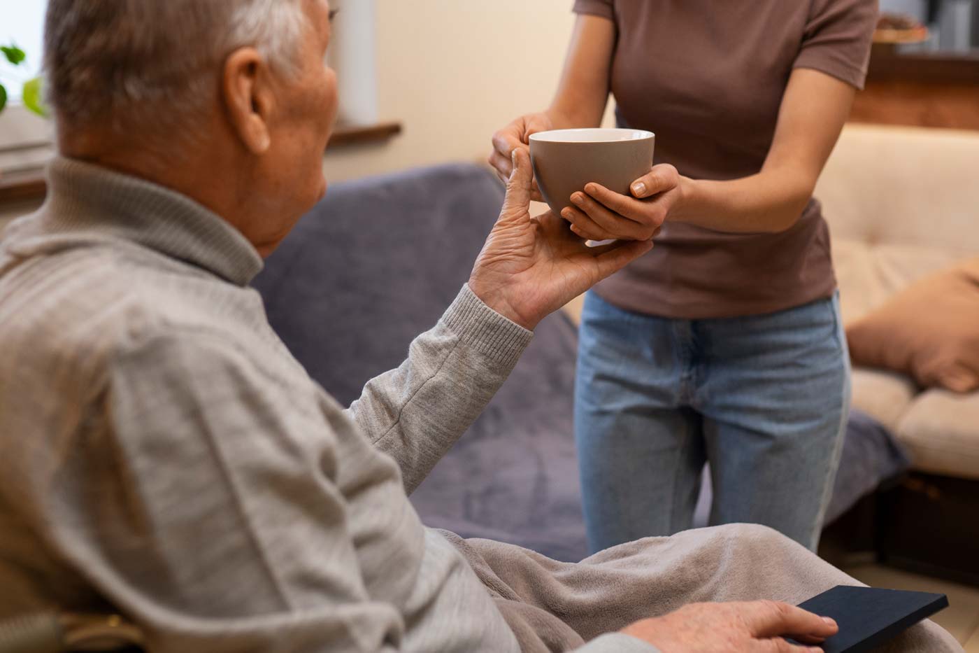 elderly man being helped from his daughter for daily tasks