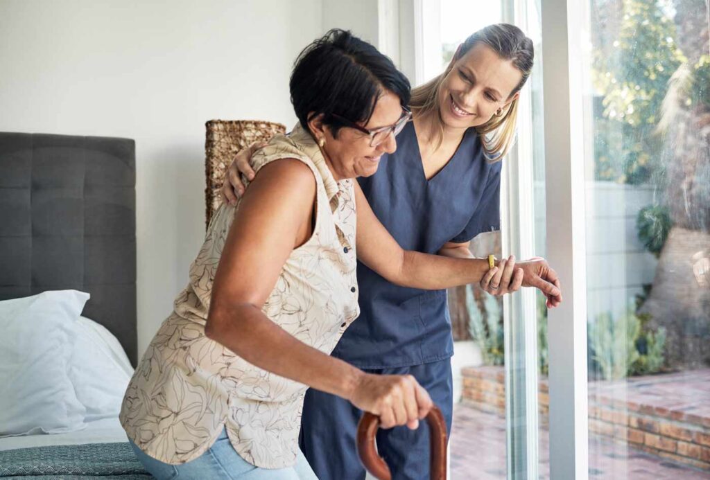 caregiver helping patient get out of bed walking