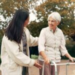 family caregiver helping mother walk outdoors