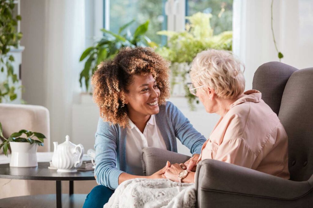 caregiver smiling with elderly disabled patient