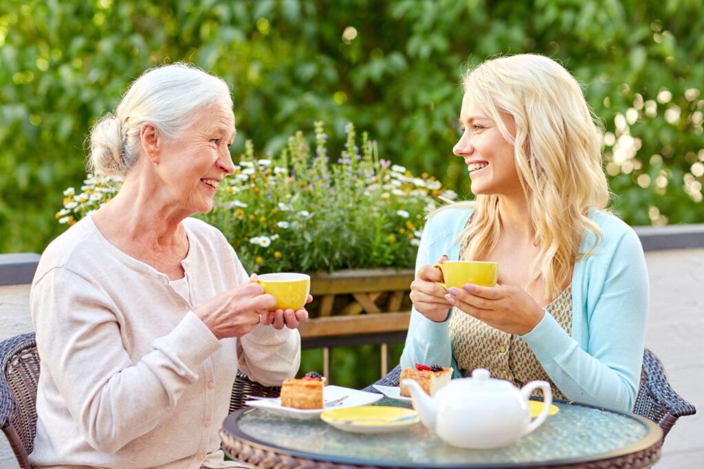 daughter with senior mother drinking tea at cafe