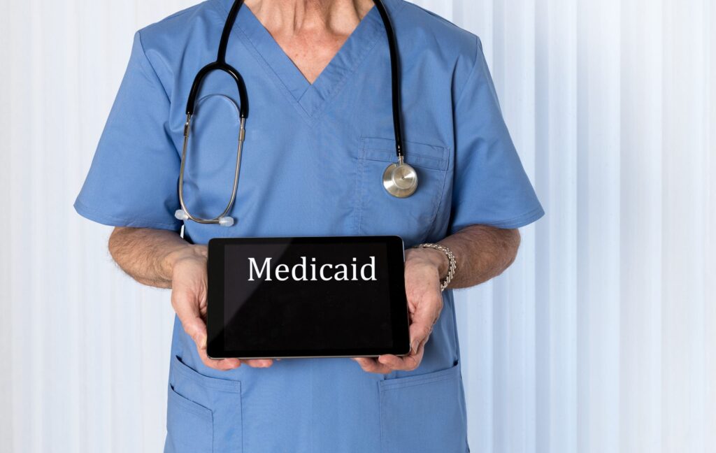 medicaid written on a tablet being held by a nurse