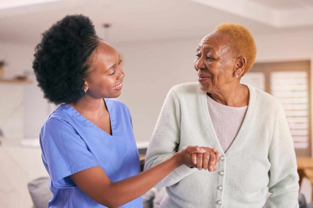 caregiver helping elderly woman walking