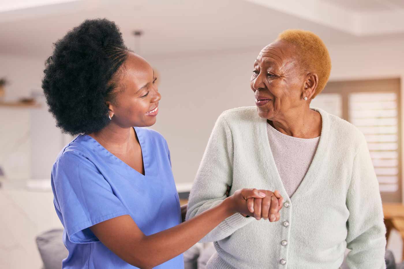 caregiver helping elderly woman walking